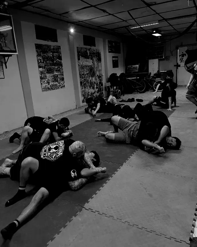 Parejas practicando en el suelo sobre un tatami rojo y azul